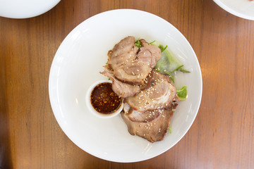  Fried sliced pork with garlic in white dish on wood table