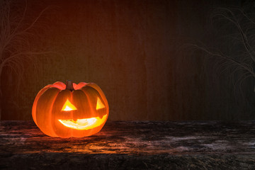 Happy halloween funny pumpkin Jack O'Lantern smiling face on grunge wood bokeh night dark background: Scary cute squash with candle light lit inside: Autumn holiday celebration festival decoration