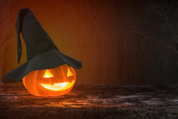 Happy halloween funny pumpkin Jack O'Lantern smiling face on grunge wood bokeh night dark...