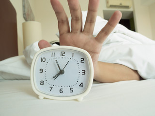 white alarm clock and sleeping man
