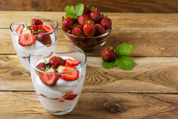 Whipped cream with strawberry on wooden background