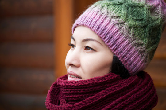 Beautiful brunette woman wearing knitted scarf and hat.