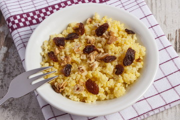 Cooked millet groats on white plate, healthy food and nutrition