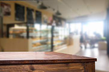 Selected focus empty brown wooden table and Coffee shop blur bac