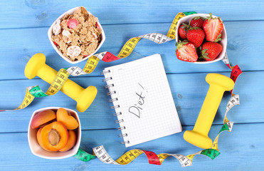 Healthy food, dumbbells, centimeter and notebook for notes, slimming, healthy and sporty lifestyle