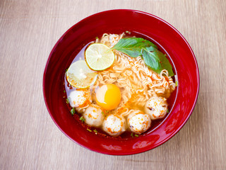 Thai style noodle, Mama soup Tom Yum Kung topped with egg and pork balls.