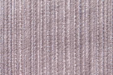 Brown background of a knitted textile material. Fabric with a striped texture closeup.