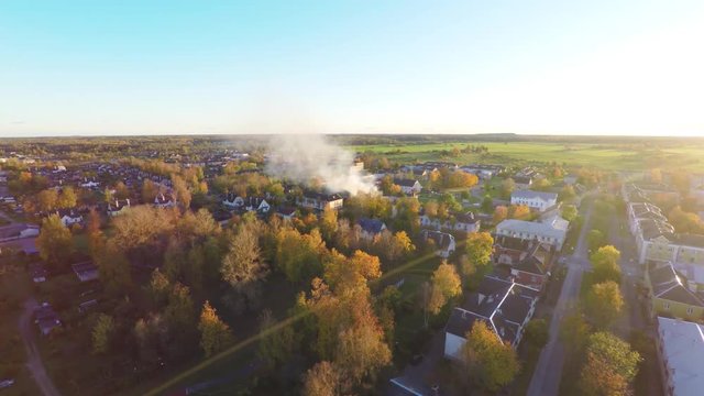 Intense fire in house. Blazing flame from windows and doors. Autumn / fall city landscape. Aerial footage.