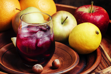 Red wine with fruit and ice on a dark wooden background, selecti