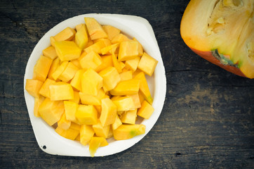 Autumn raw sliced pumpkin on rustic wooden background