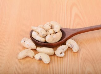cashew nut in wooden spoon on wood table