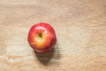 Red apple on a brown bright wooded table