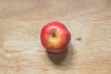 Red apple on a brown bright wooded table