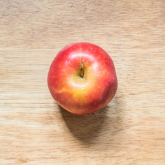 Red apple on a brown bright wooded table