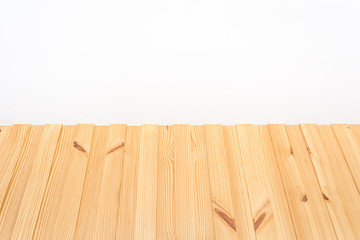 Brown wooden floor with bright white wall texture.