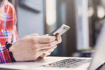 Young man texting on his smartphone on a urban background