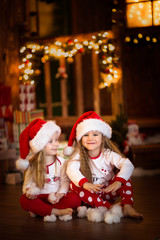 Girls sister friends hugging sitting at  Christmas tree, concept