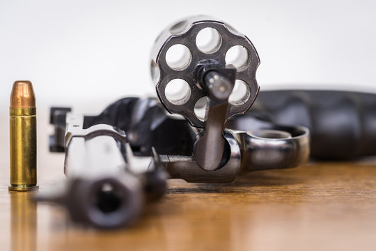 Close up view of bullet and handgun. Shallow depth of field. Focus on a bullet. Vertical view.