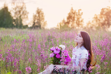 brunette girl with flowers at sunset