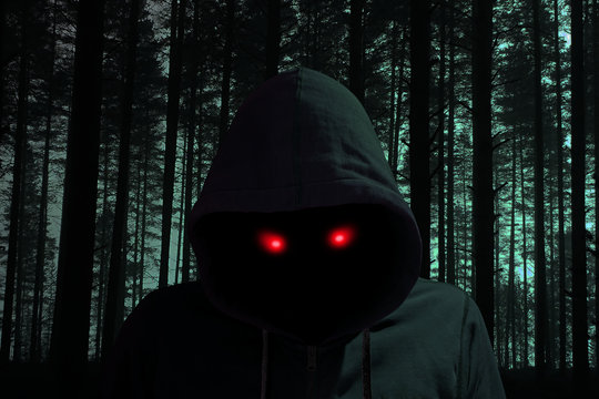 Dark man with hoddie in black forest red eyes