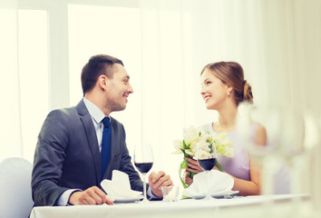smiling man giving flower bouquet at restaurant