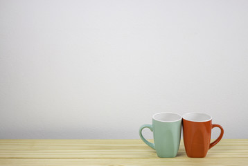 green and red coffee mug on wooden table. focus on mug