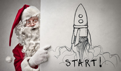 Santa Claus pointing at a rocket