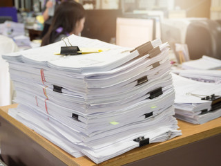 Business workload concept. Pile of unfinished business documents on office desk