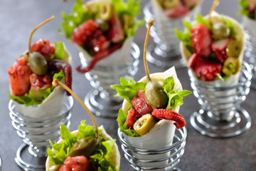Partyfood: Mini-Wraps gefüllt mit Oktopussalat mit Oliven und Kapern - Mini tortillas stuffed with octopus salad with olives and capers, served in wire egg cups
