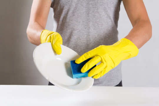 Young man wearing yellow rubber gloves. Ready to cleaning