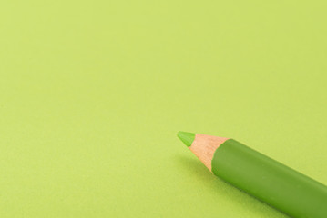 Isolated green pencil on light green paper background