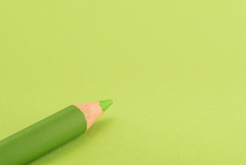 Isolated green pencil on light green paper background