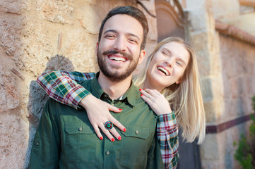 Having fun together. beautiful young loving couple standing outdoors together while woman hugging her boyfriend and smiling
