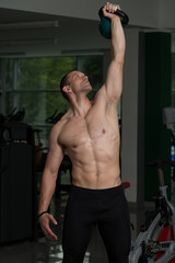 Obraz na płótnie Canvas Man Exercising With Kettle Bell