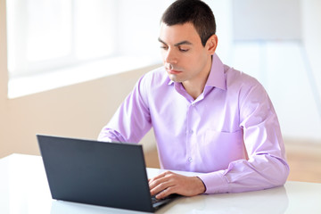 Portrait of young business man with laptop in the office