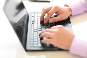 Male hands typing on laptop keyboard