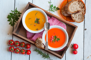 Pumpkin and tomato soups on wooden tray