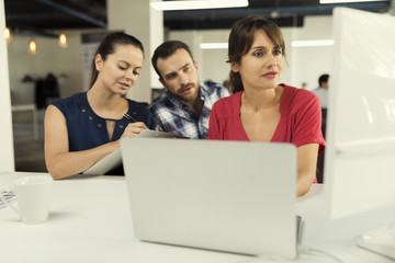 Mature business woman manager with her team working on computer