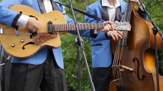 Jazz band playing musical instruments. Musicians singing playing jazz, swing, blues, rock and roll music. Orchestra, double bass, electric vintage retro guitar. Big band. Swing live concert. Closeup