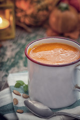Thanksgiving Pumpkin soup on rustic background with copy space 