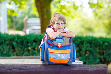 little kid boy with school satchel on first day to school  - obrazy, fototapety, plakaty