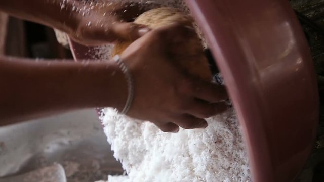 Woman on a public market extraction of coconut shavings.Asian market