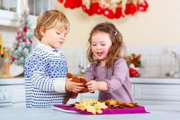 Littlke kid boy and girl baking gingerbread cookies 