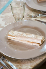 silverware and cutlery sets and glasses on a linen tablecloth