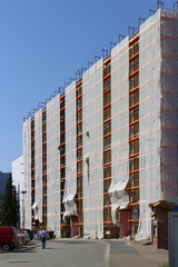 White protective canvas on scaffolding for reconstruction facade in Ruzomberok, Slovakia