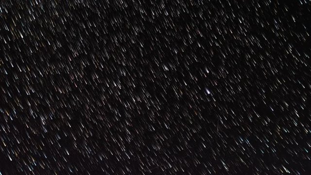 time-lapse of stars moving through the night sky, first as spots of light and then gradually as star trails 