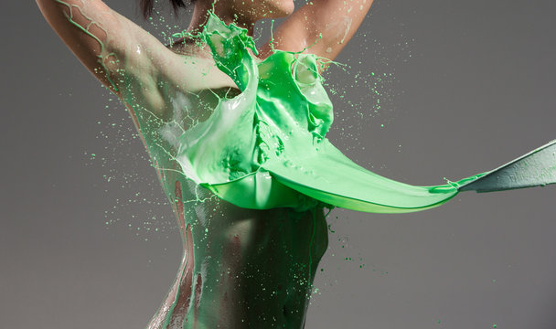 The beautiful woman with green liquid paint over her body