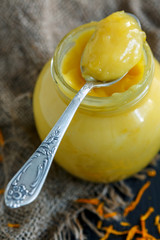 Jar with lemon custard and a teaspoon.
