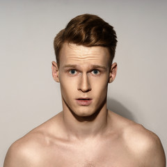 Obraz premium Studio fashion style portrait of young calm handsome red hair man. Closeup face portrait on gray background