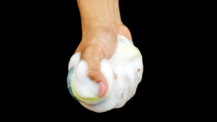 Man holding a sponge in his hand on black background.